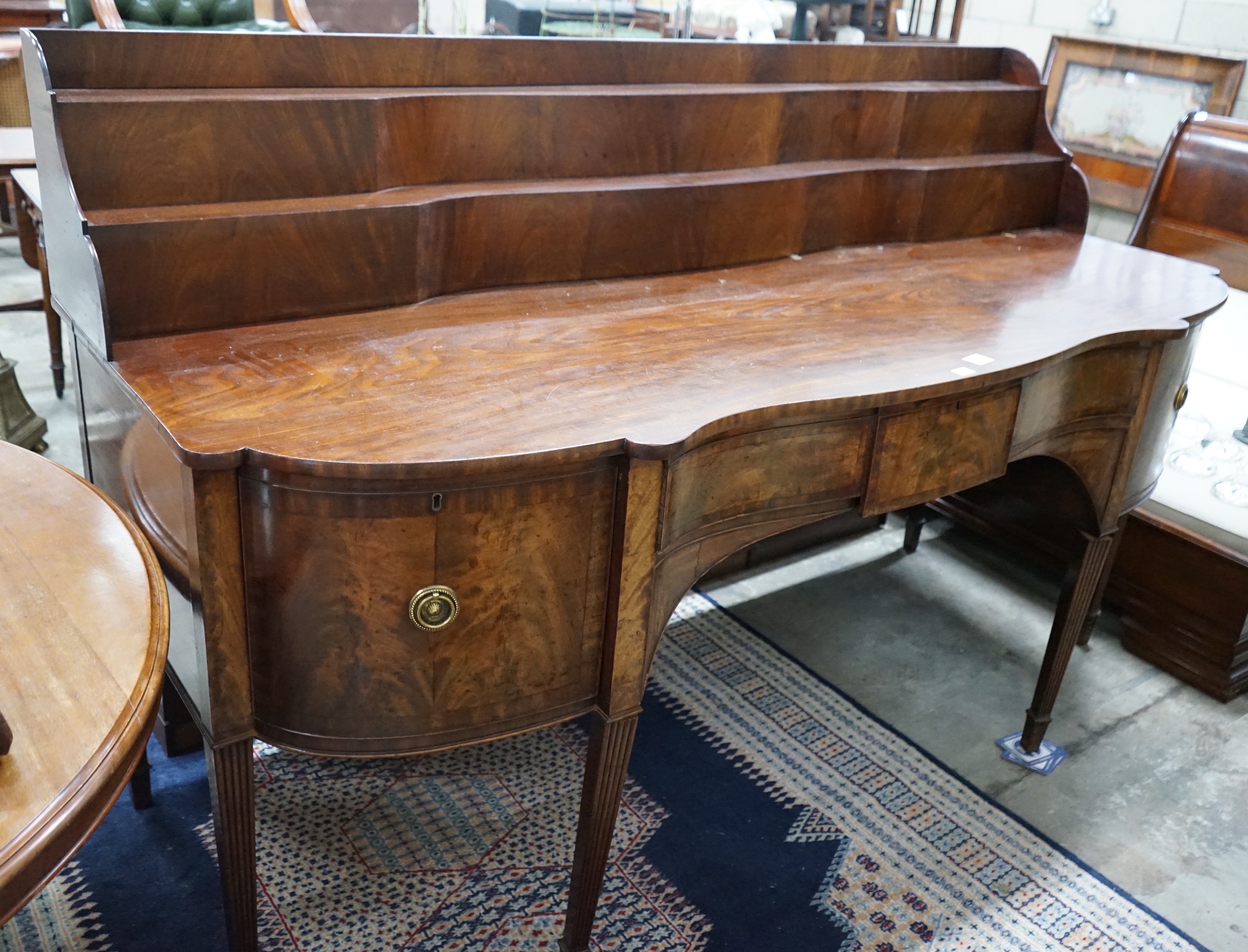 A George IV mahogany serpentine sideboard, width 214cms, depth 86cms, height 132cms.